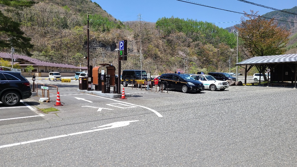 Near the entrance of the second parking lot and the waiting area for taxis